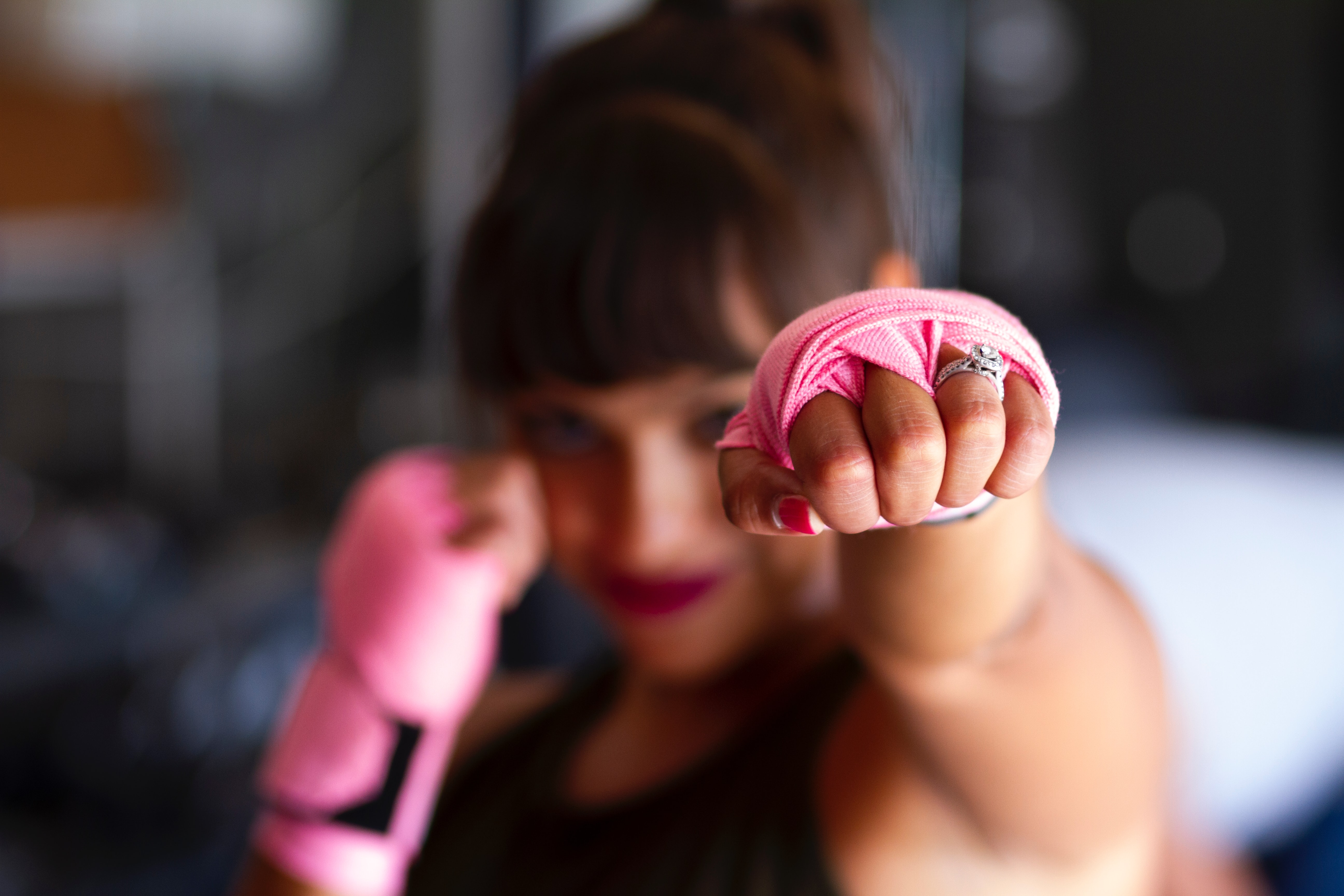 woman punching, fist with pink wrapping