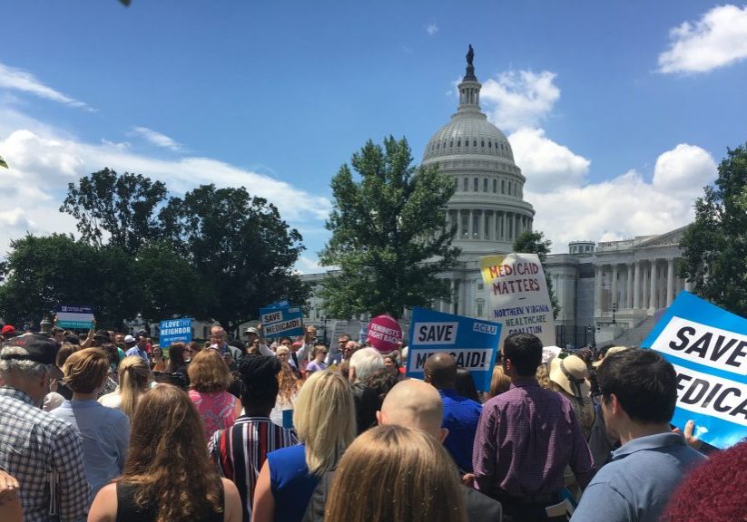 Photo of protesters in front of a Capitol building holding signs that read "SAVE MEDICAID"