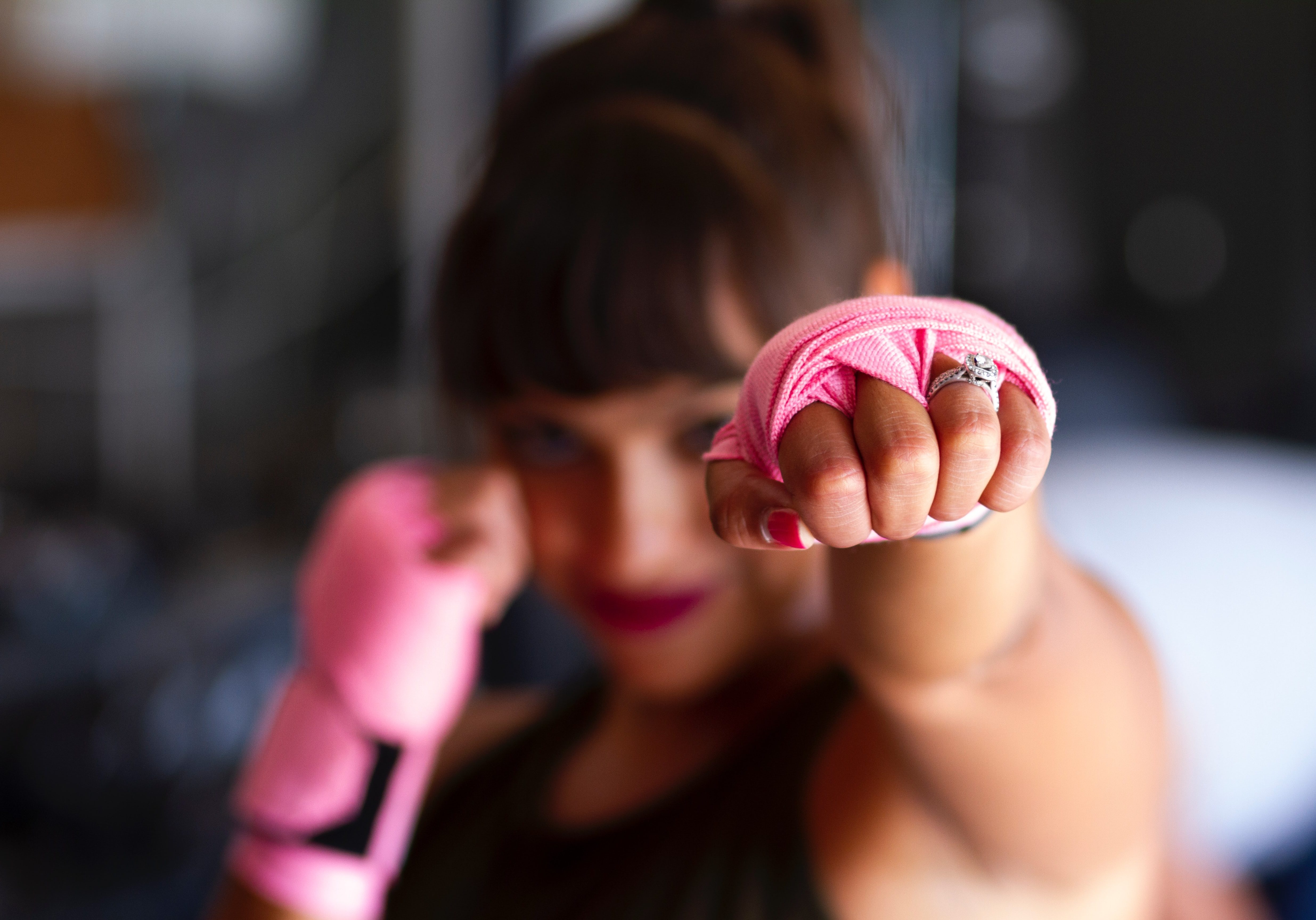 woman punching, fist with pink wrapping